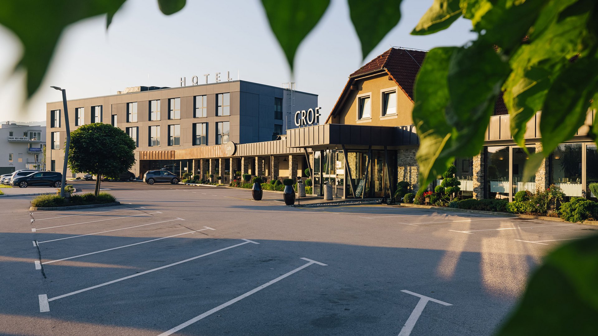 Hotel Grof **** © Ziga Intihar Leerer Parkplatz vor modernem Hotelgebäude bei Tageslicht