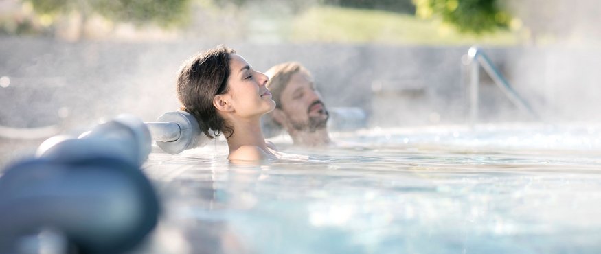 Two relaxed people in an outdoor hot tub