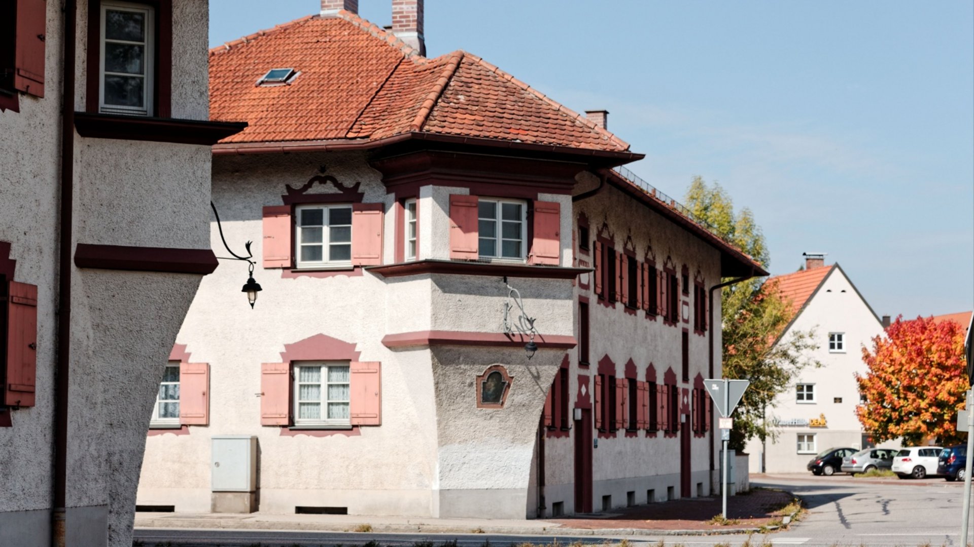 Traditional German house with red shutters and tiled roof on a quiet street