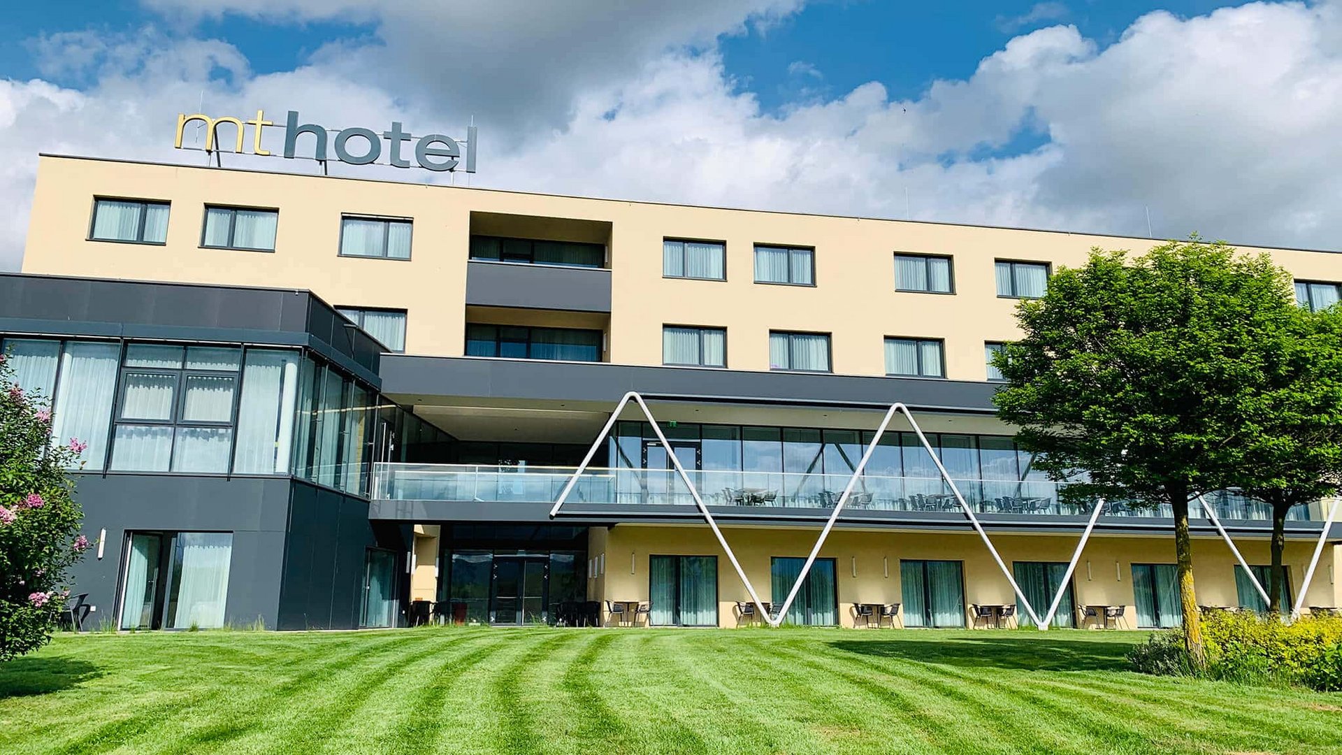 Modern hotel building with green lawn and blue sky