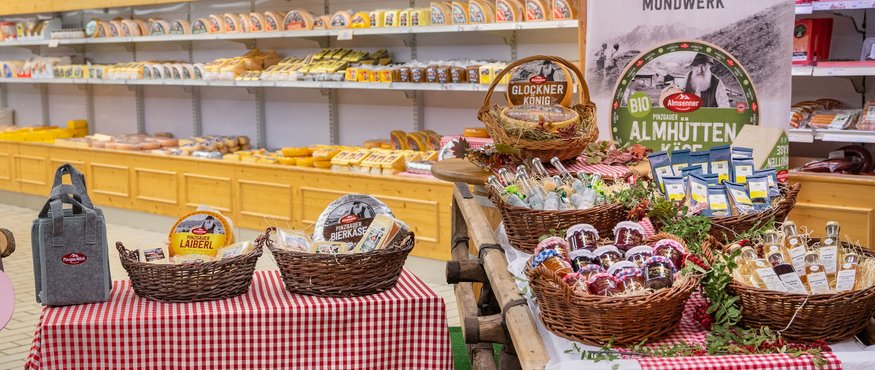 Cheese and local products displayed on tables with red and white checkered cloths