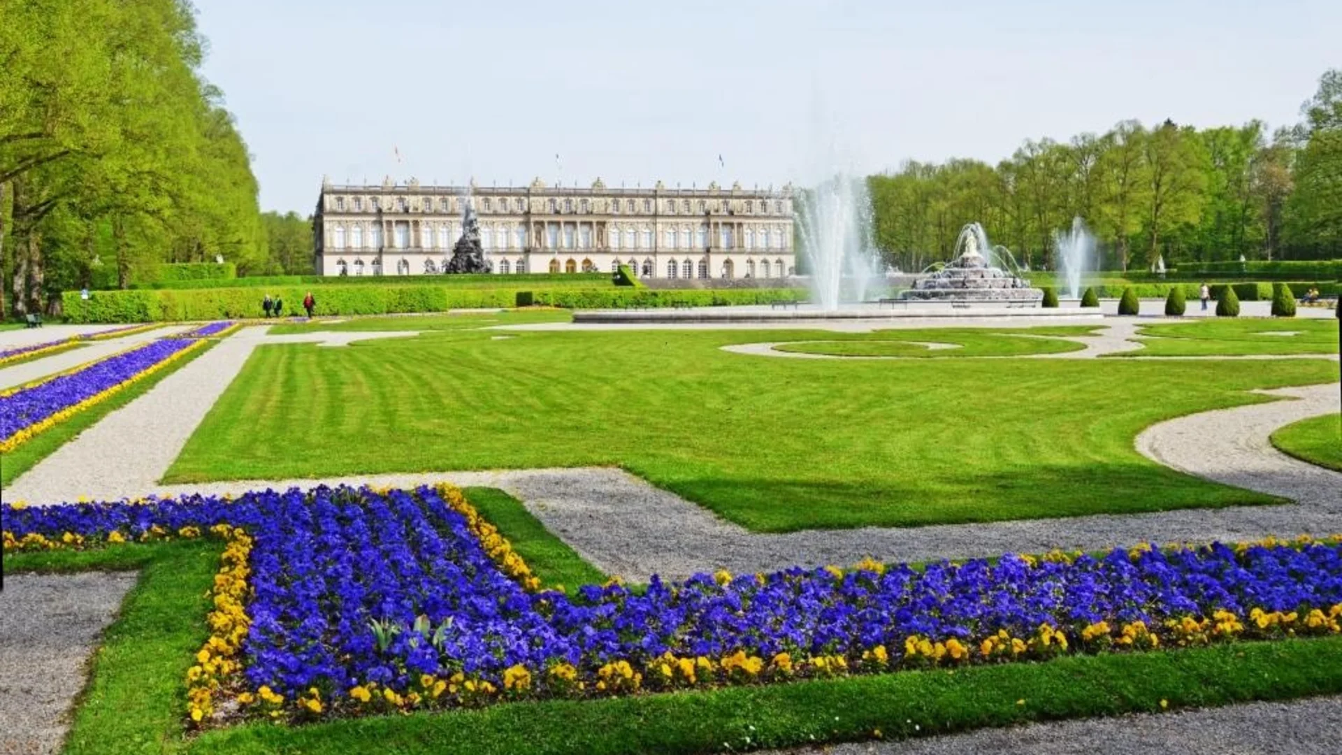 Herrenchiemsee paleis met fontein en kleurrijke bloembedden in de tuin