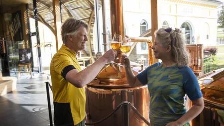 7 Quellen der Entschleunigung © Velontour - Heiko Mandl Paar stößt mit Biergläsern in Brauerei an