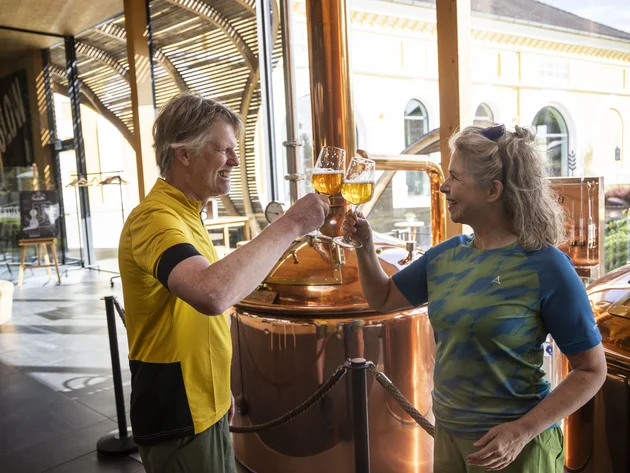 7 Quellen der Entschleunigung © Velontour - Heiko Mandl Paar stößt mit Biergläsern in Brauerei an