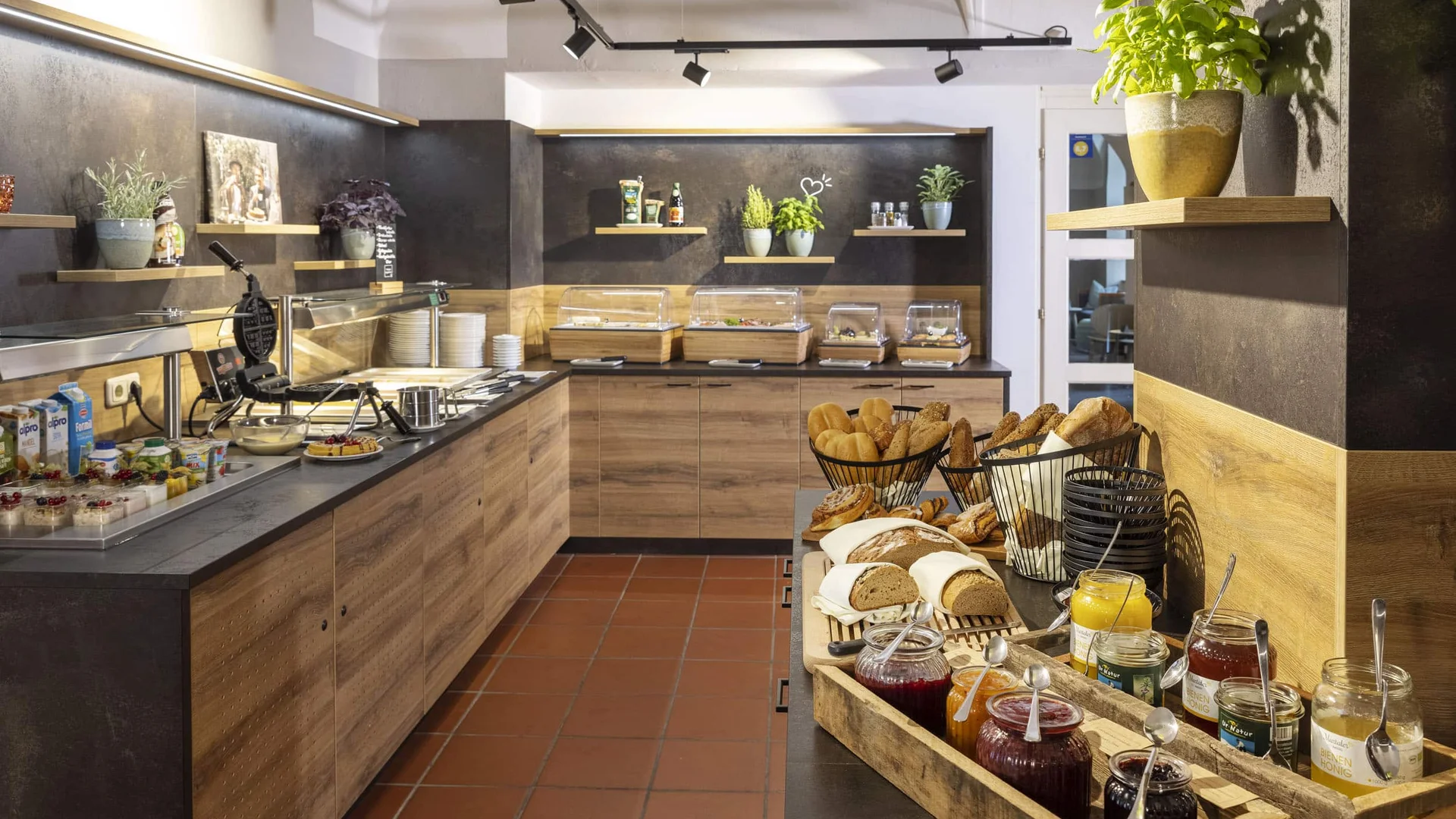 Breakfast buffet with bread, jams, and coffee machine