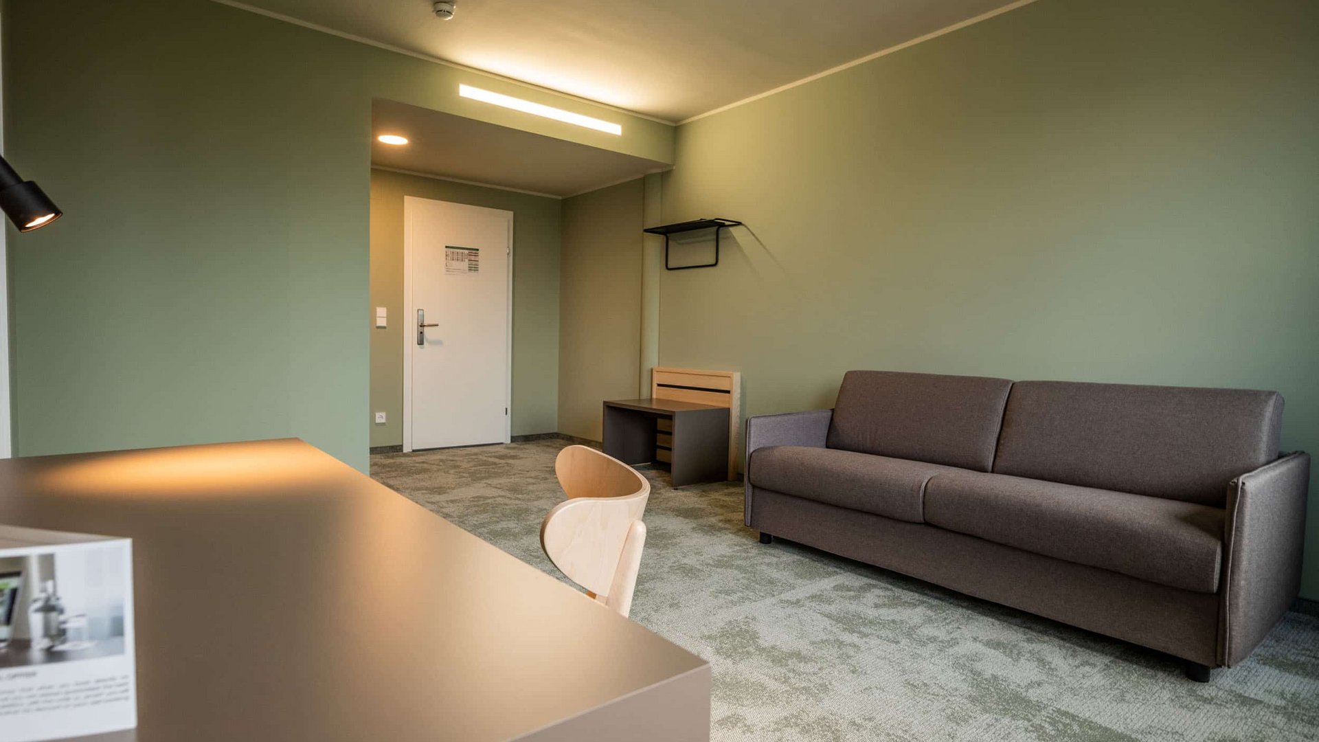 Modern room with sofa, desk, and chair