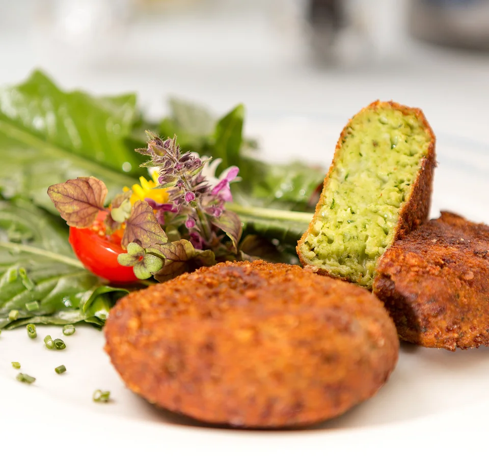Falafel met bladgroente en tomaat op witte bord