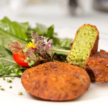 Falafel met bladgroente en tomaat op witte bord