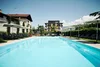 Collective enquiries © Manuel Ferrigato View of an outdoor pool with loungers and umbrellas in front of a building