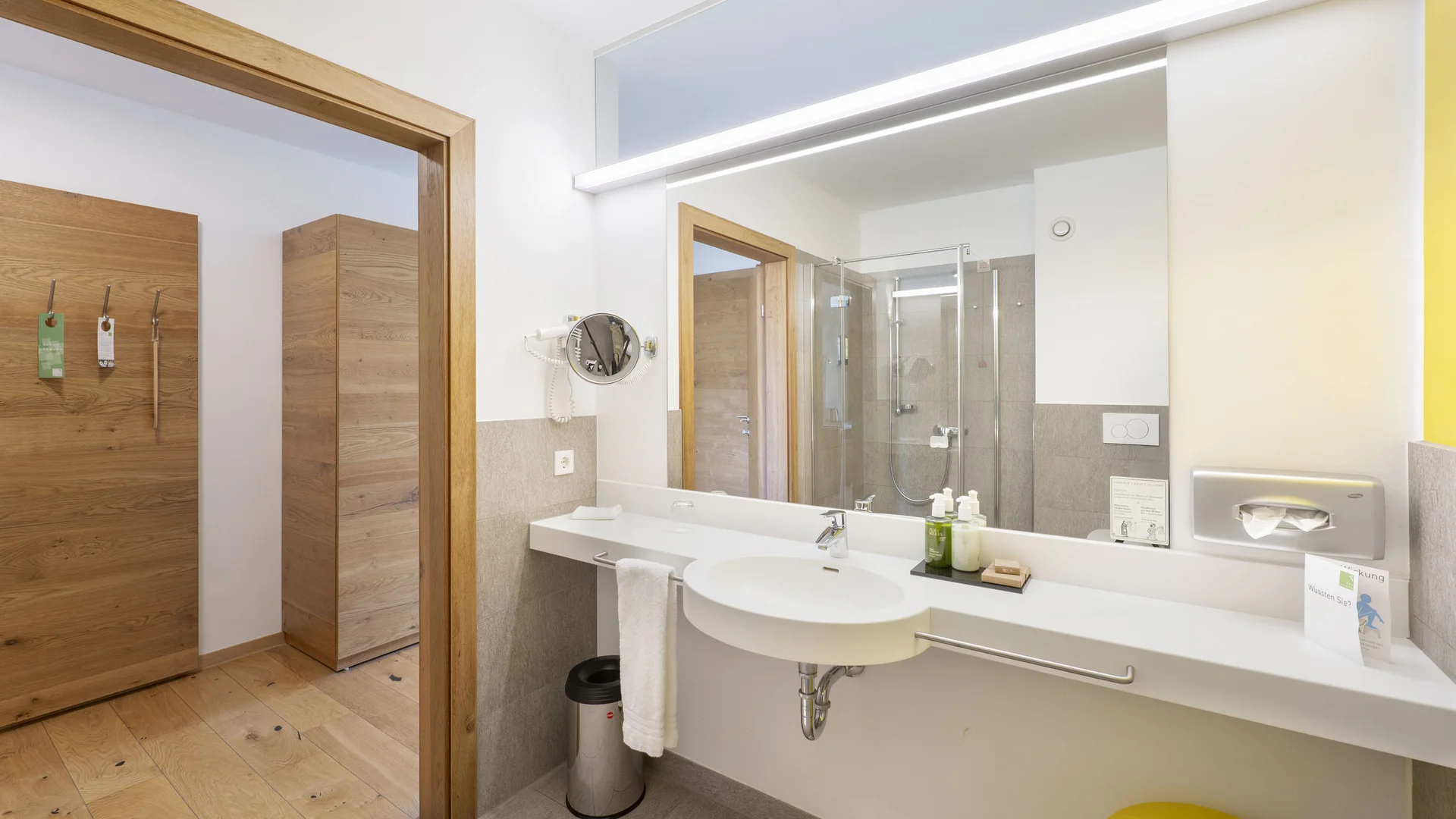 Helles Badezimmer mit großem Spiegel, Waschbecken und Holzdetails