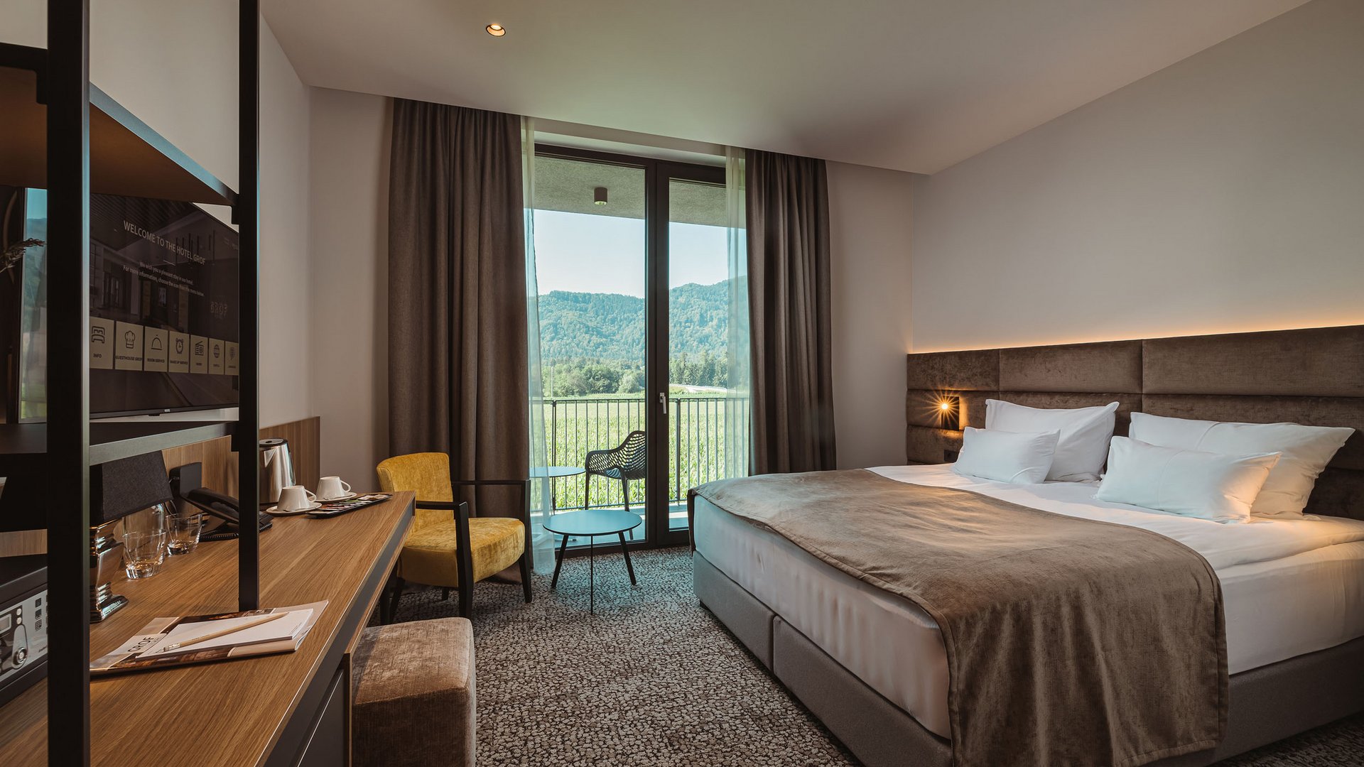 Hotel Grof **** © Ziga Intihar Modernes Hotelzimmer mit Doppelbett und Balkon mit Bergblick