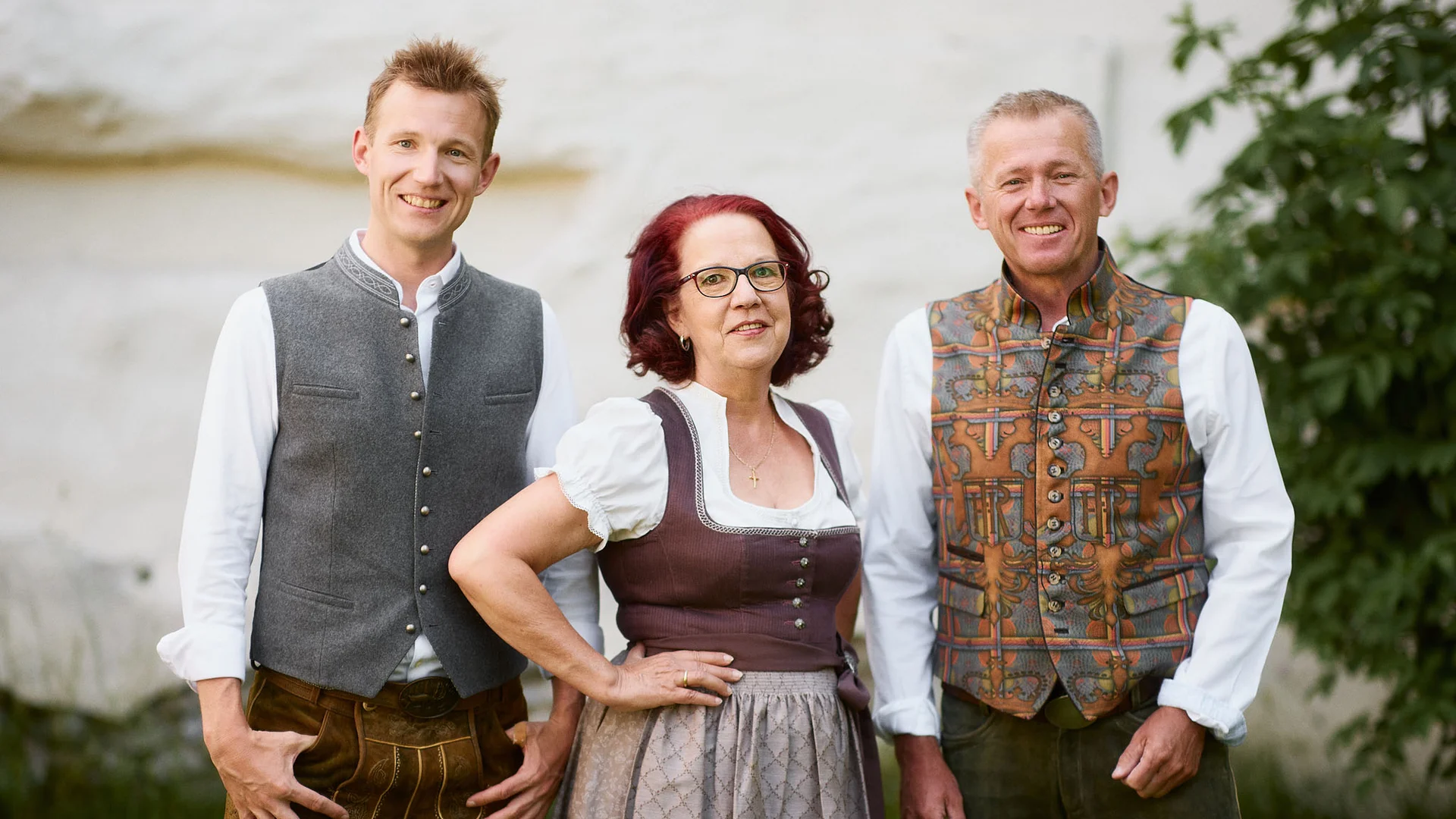 Gasthaus-Hotel Oberwirt **** © Julian Höck Drie mensen in traditionele Beierse kleding glimlachen naar de camera