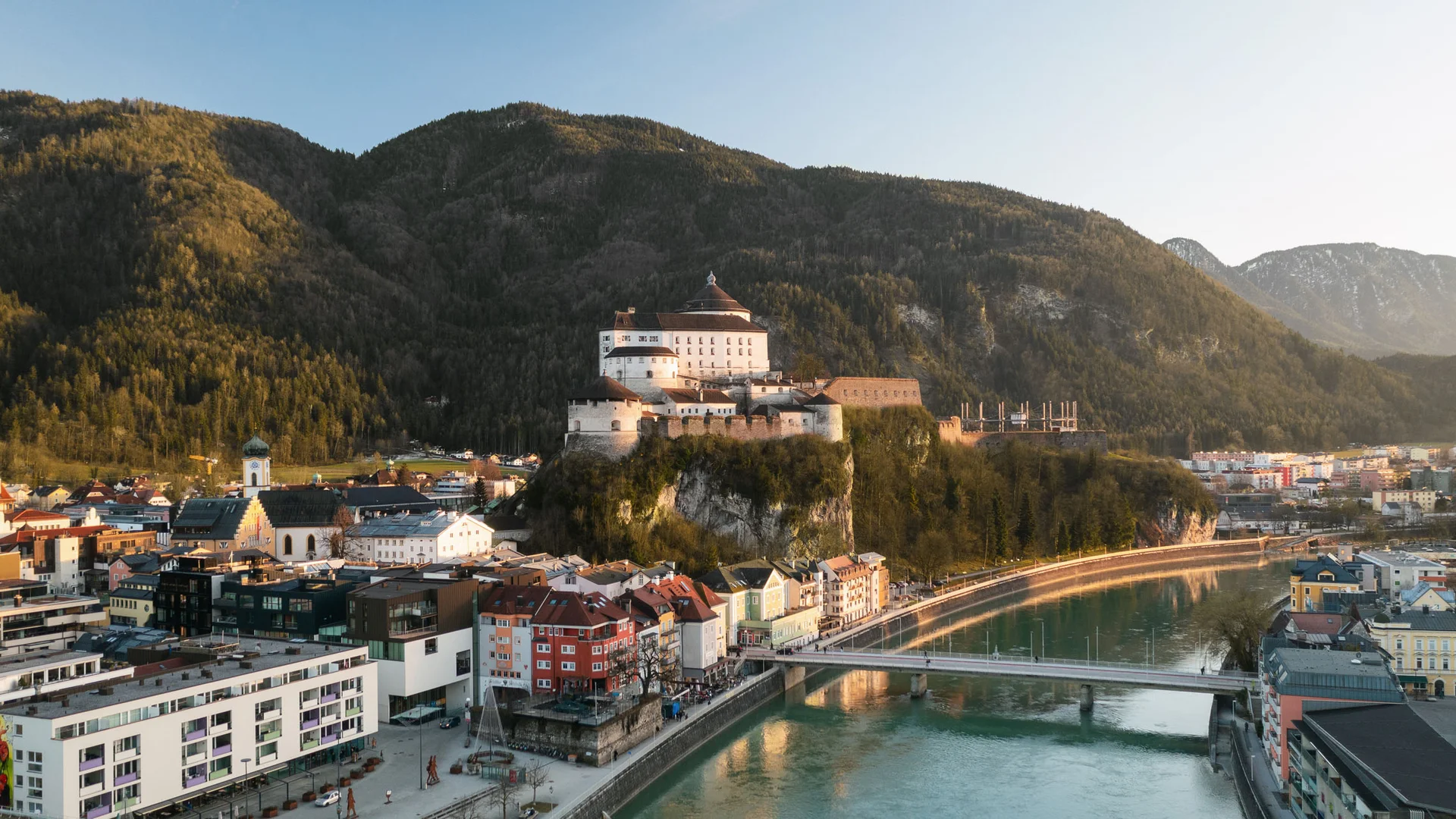 Blick auf eine Burg auf einem Felsen mit Stadt und Fluss im Vordergrund
