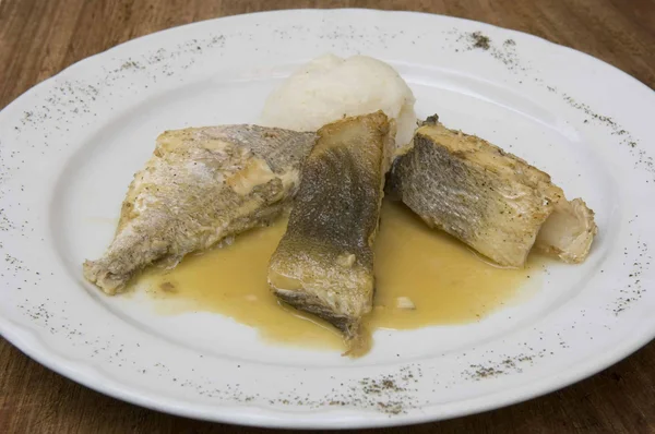 Gradese fish soup © Gianluca Baronchelli Three pieces of cooked fish on white plate with sauce and side