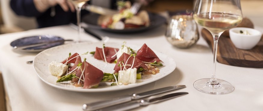 Set table with gourmet dish and white wine glass in elegant restaurant