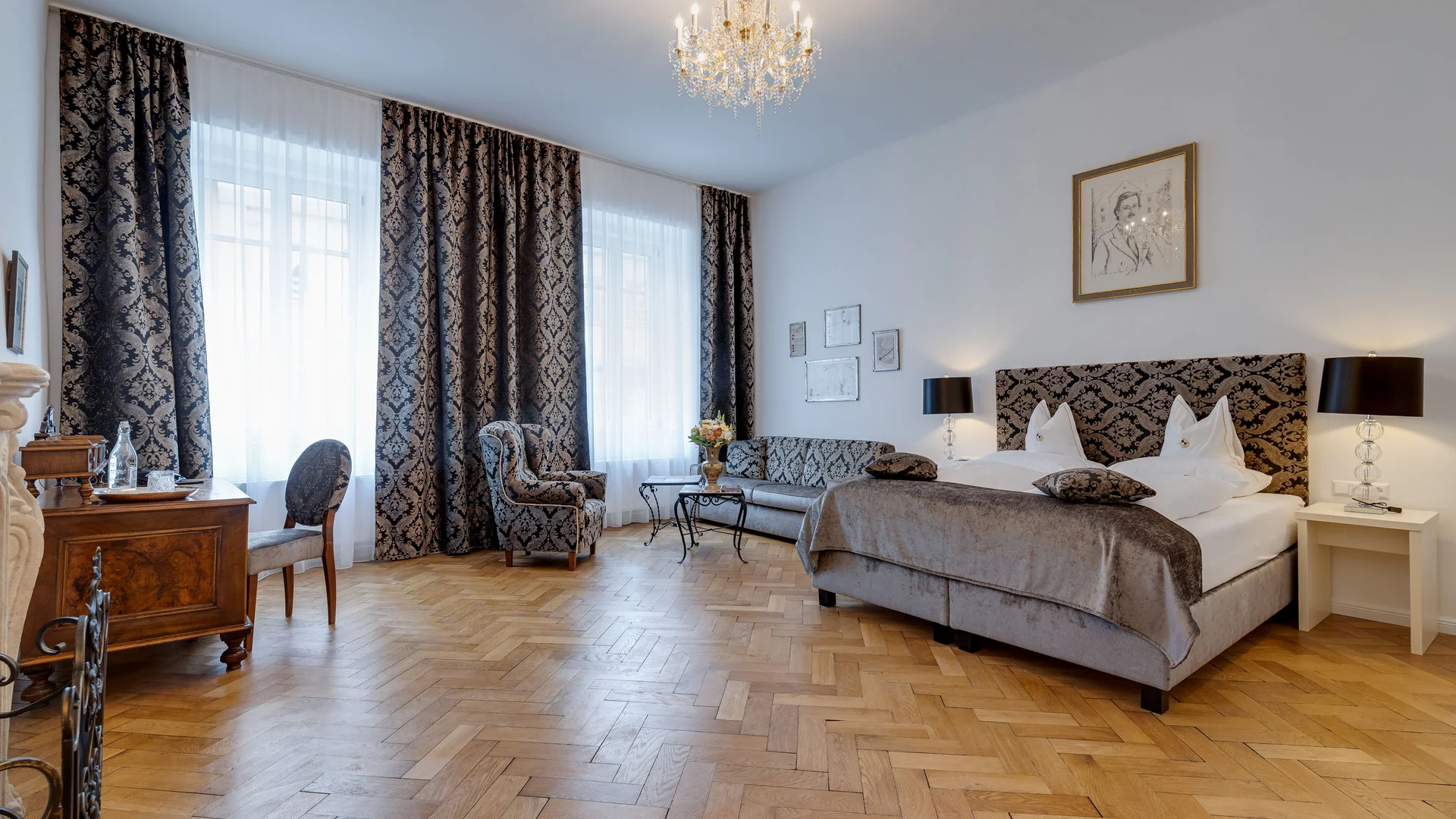 Elegant hotelkamer met houten vloer, tweepersoonsbed en antiek meubilair