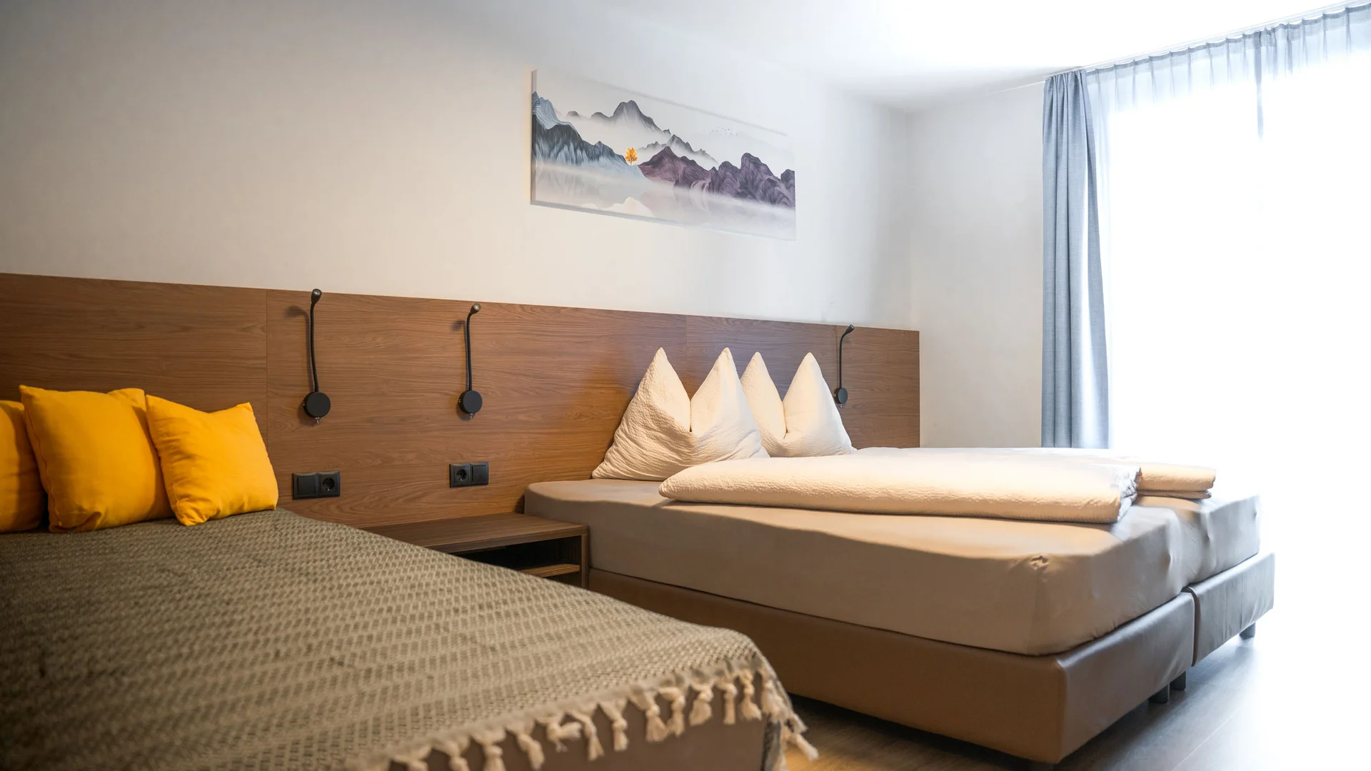 Modern bedroom with double bed, daybed, and yellow cushions