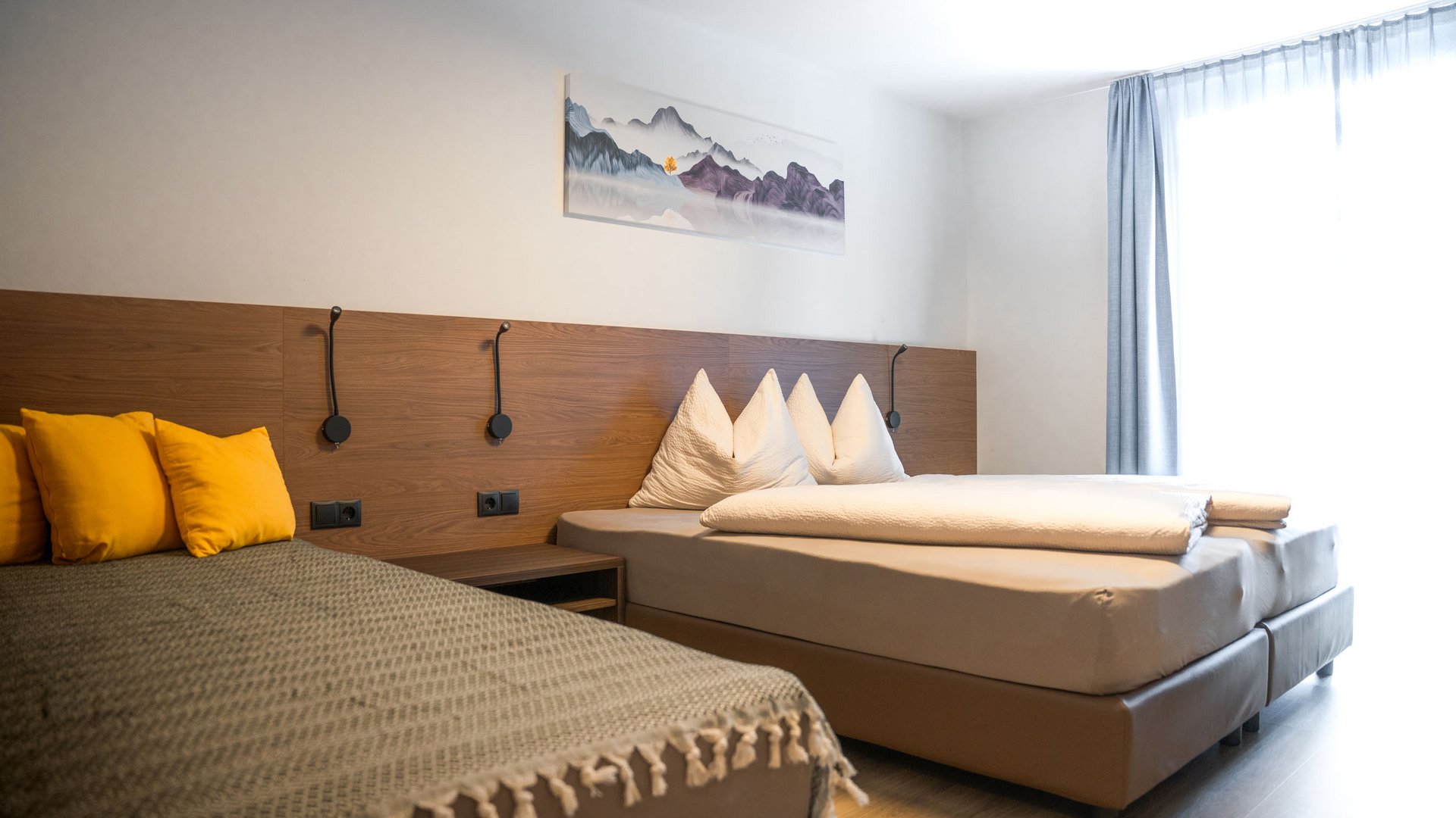 Modern bedroom with double bed, daybed, and yellow cushions