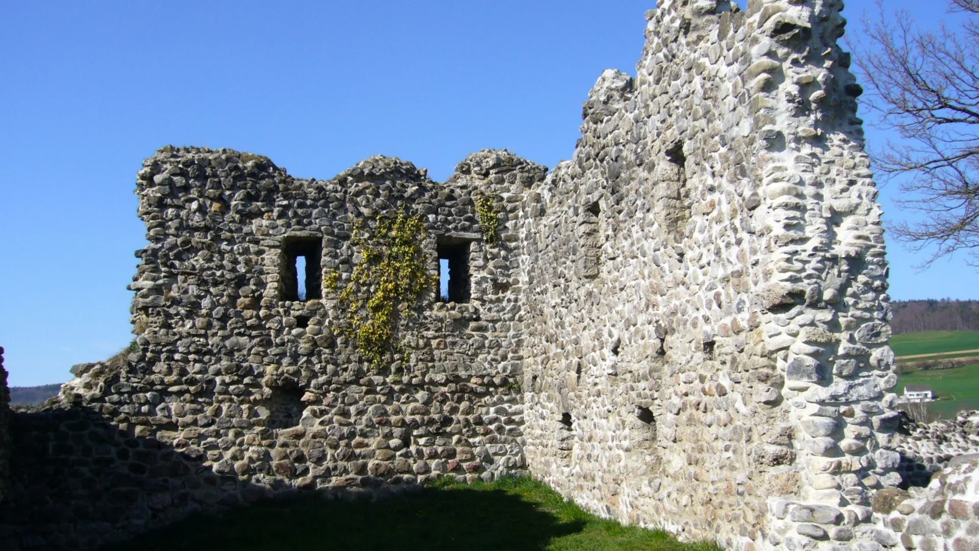 Tour detail © Peter Berger Ruins of an old stone wall under clear blue sky
