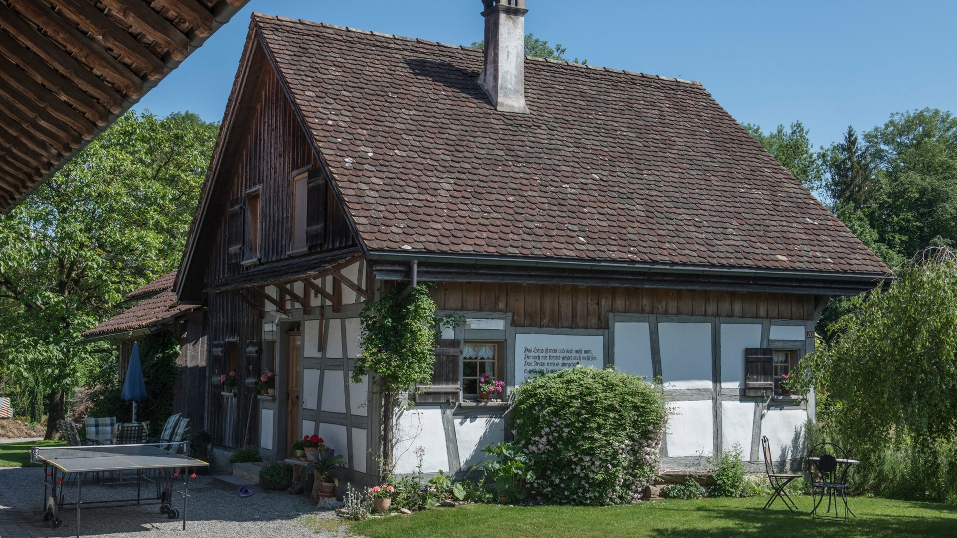 Half-timbered house with red roof and garden on a sunny day