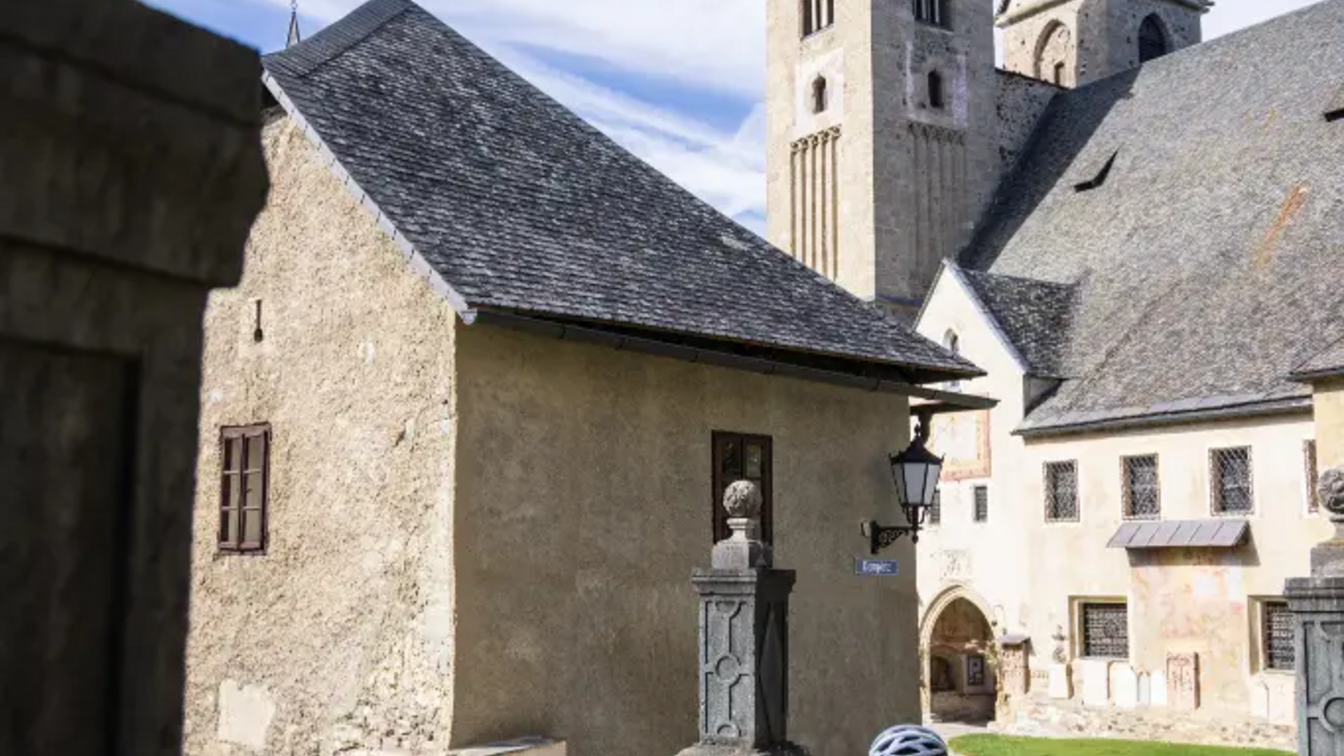 Zwei Radfahrer an historischem Gebäude mit Kirchtürmen im Hintergrund