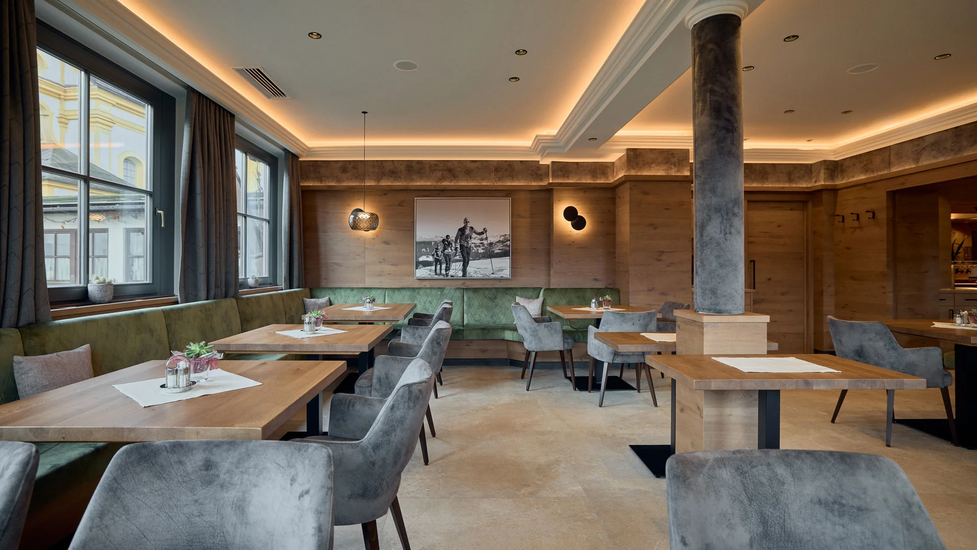 Gasthaus-Hotel Oberwirt **** © Julian Höck Modern interieur van restaurant met houten tafels en grijze stoelen