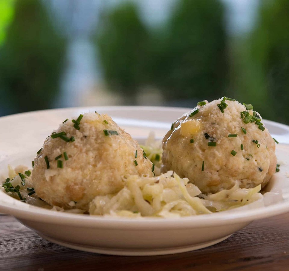 Two bread dumplings with chopped herbs on a plate