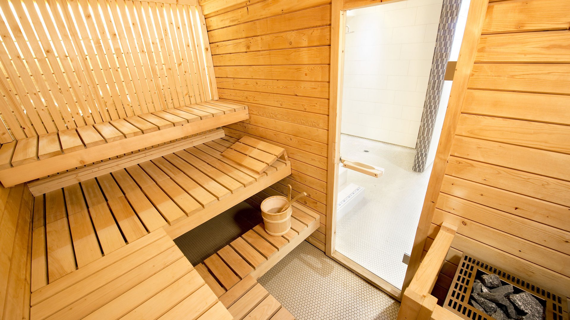 Interior of a traditional wooden sauna with benches and sauna heater