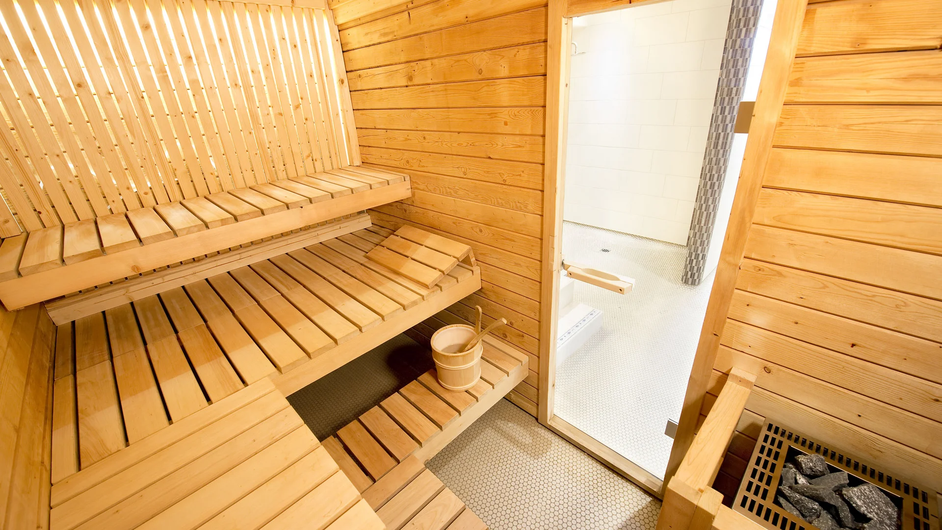 Interior of a traditional wooden sauna with benches and sauna heater