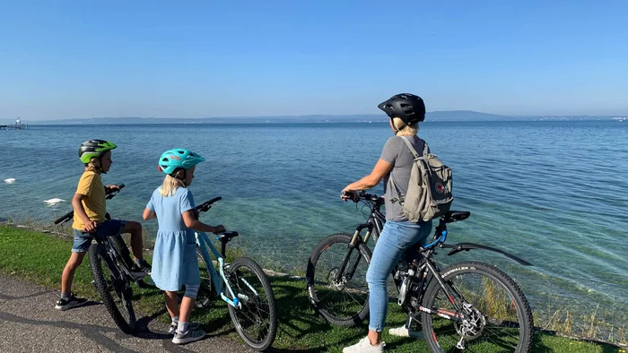 5 Radtouren durch den Thurgau © Thurgau Bodensee Tourismus Drei Radfahrer mit Helmen stehen am See und schauen aufs Wasser.