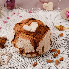 Round bread with heart shape on a crocheted lace doily