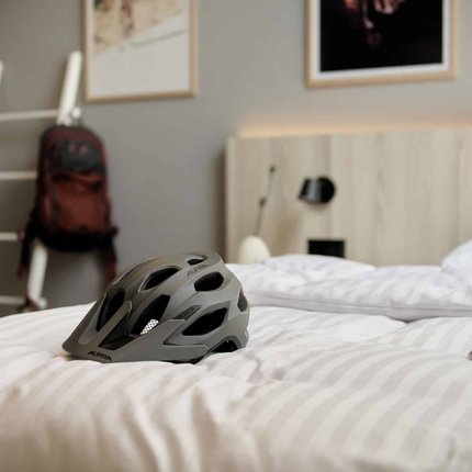 Fahrradhelm liegt auf einem Bett in einem Schlafzimmer