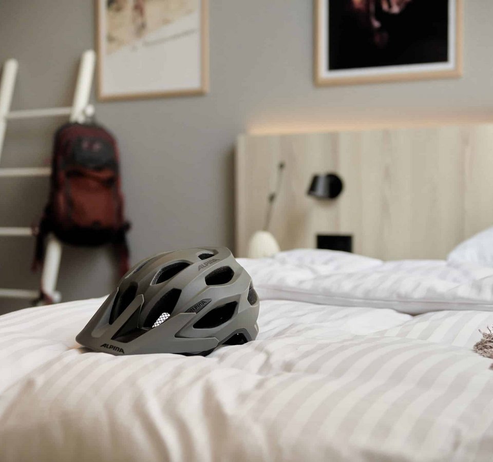Fahrradhelm liegt auf einem Bett in einem Schlafzimmer