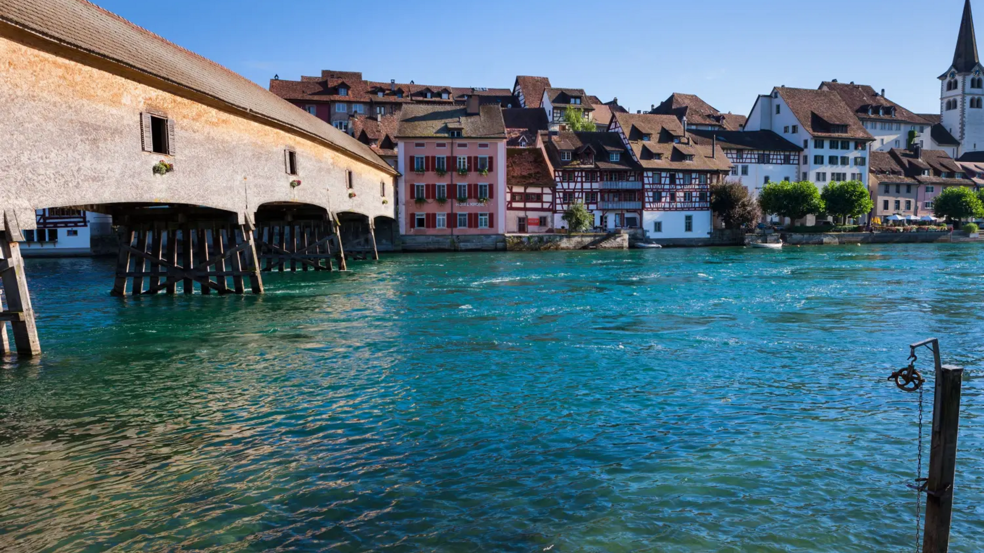 View of the historic wooden bridge and houses by the water in Switzerland