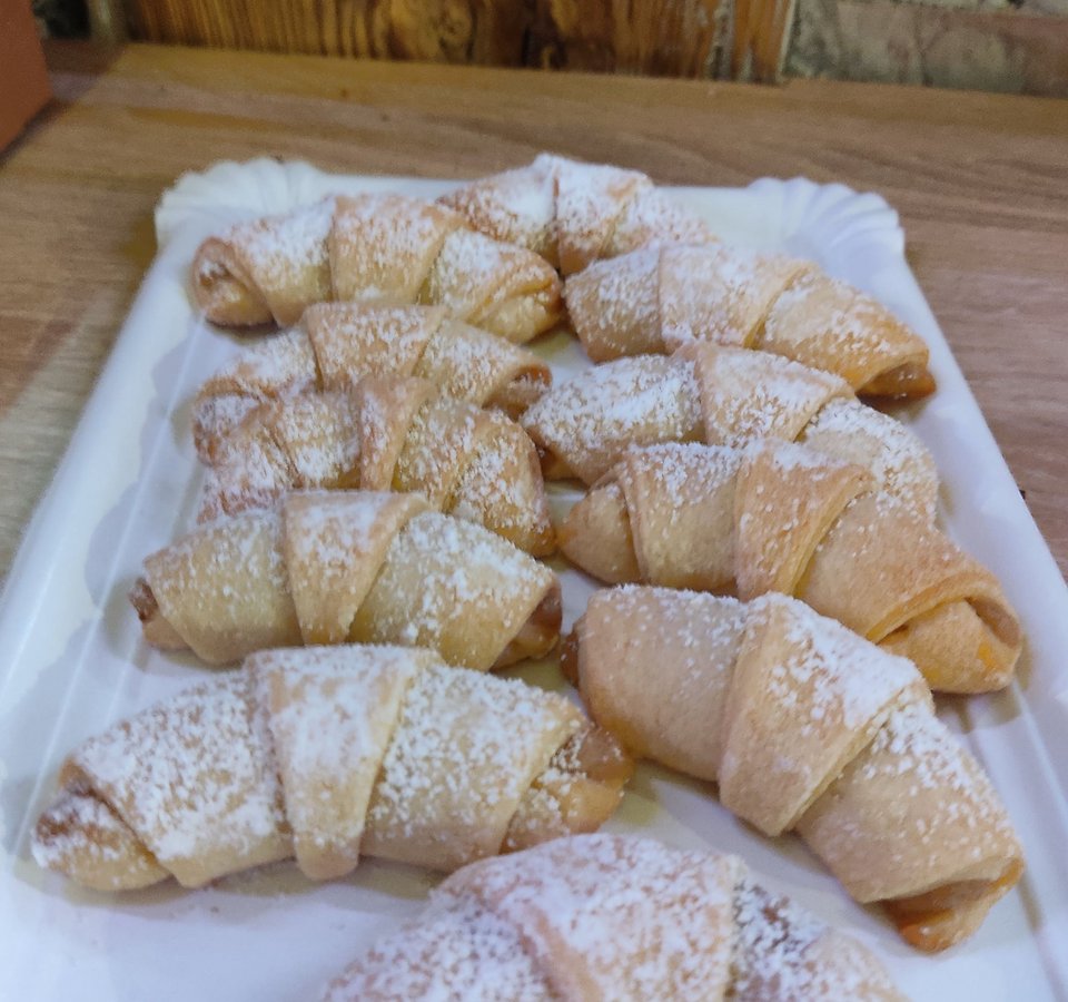 Several mini croissants dusted with powdered sugar on a white tray