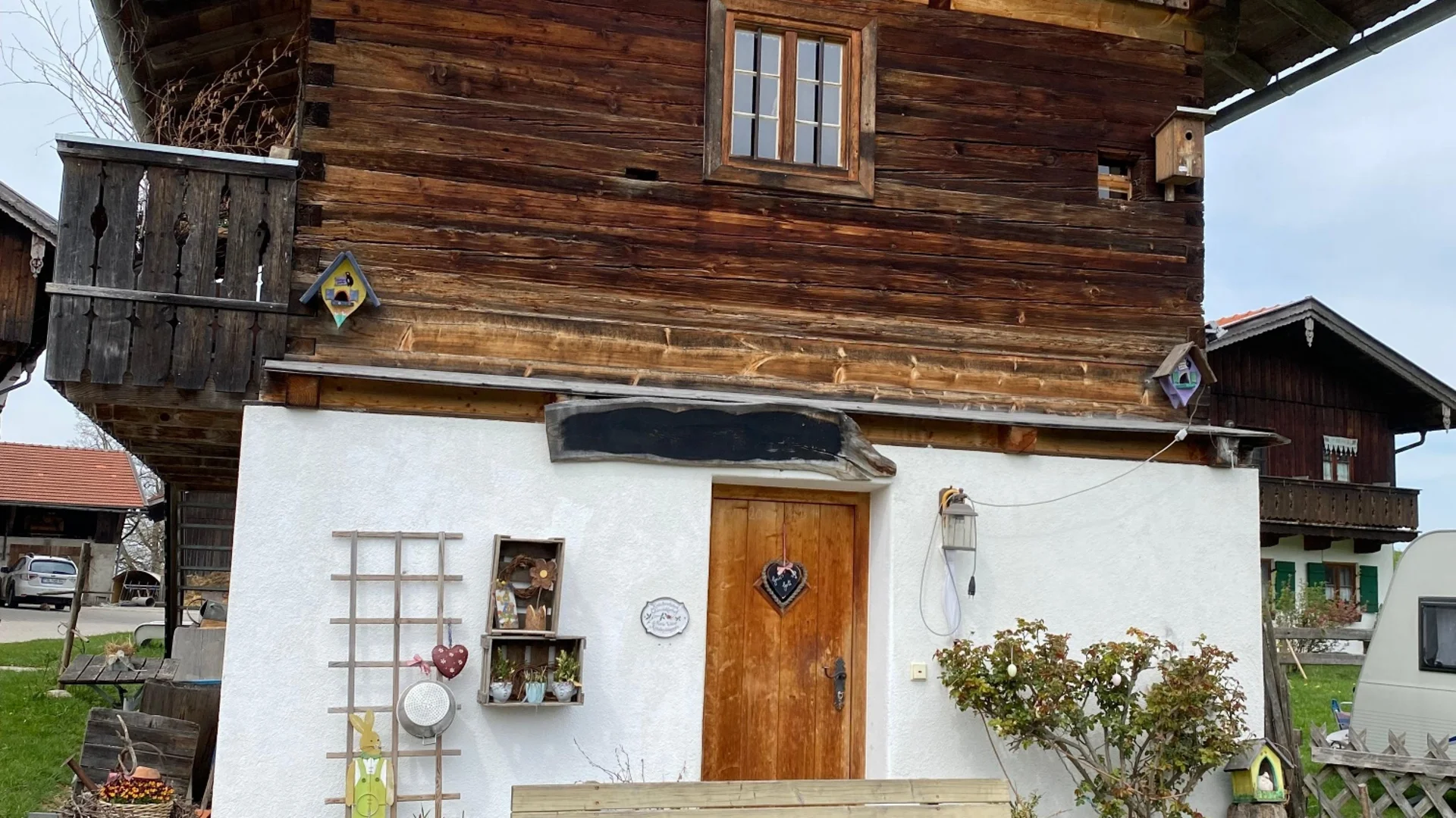 Traditionelles bayerisches Holzhaus mit Terrasse und Gartenmöbeln