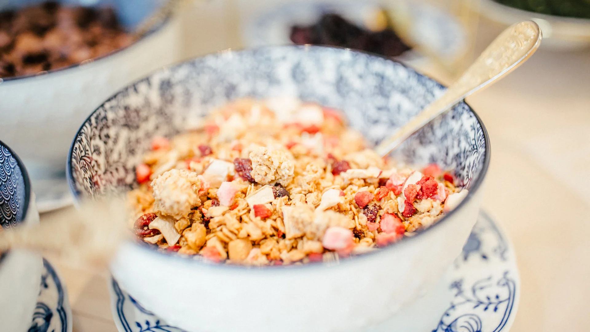 Kom met muesli en stukjes fruit, gouden lepel
