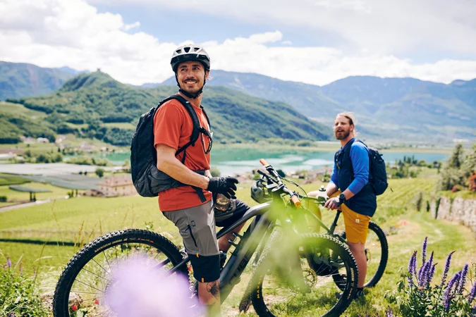 Zwei Radfahrer in den Bergen mit Blick auf See und Tal