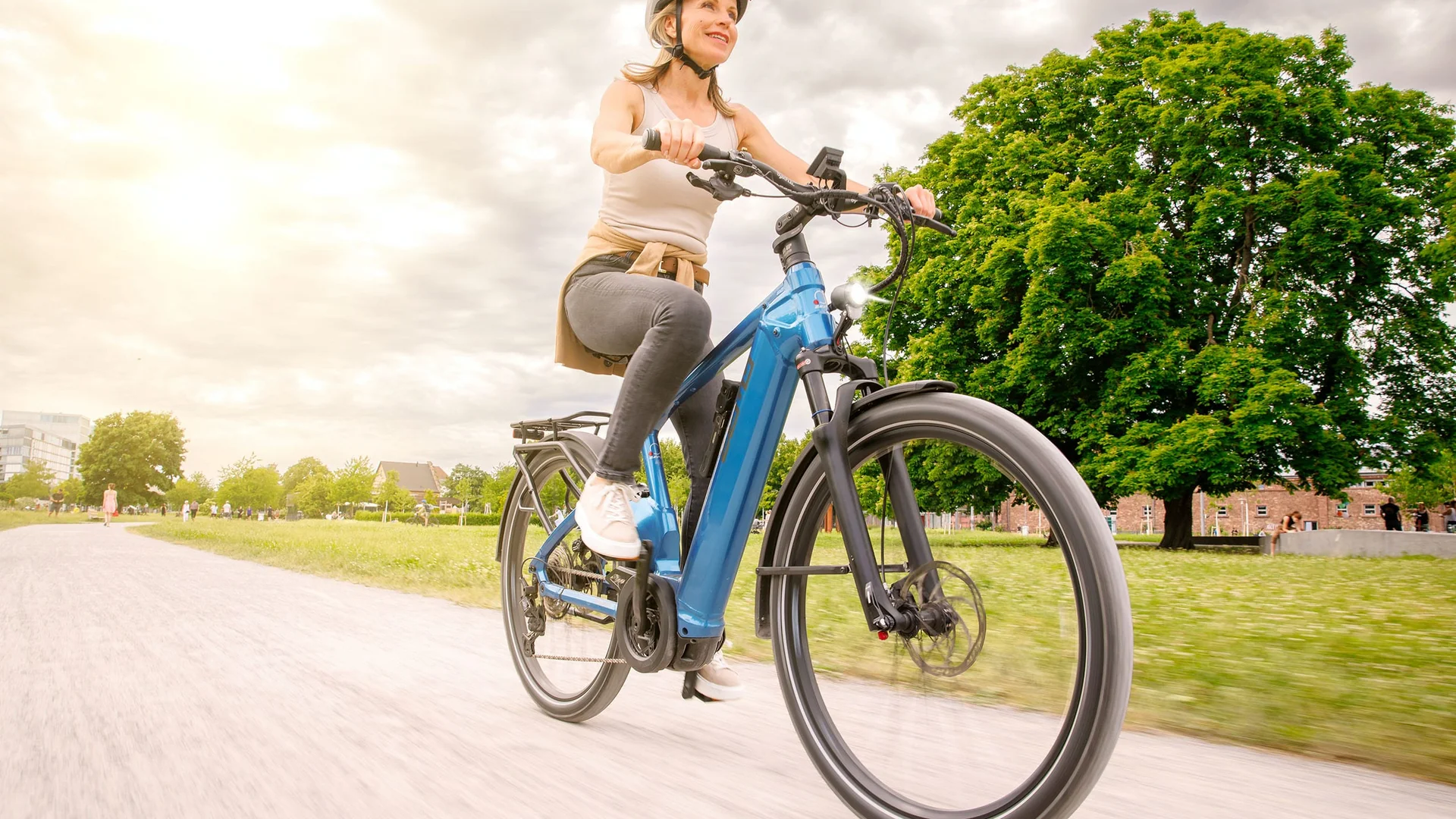 Schwalbe © Ralf Bohle GmbH Vrouw fietst op een pad in het park op een zonnige dag