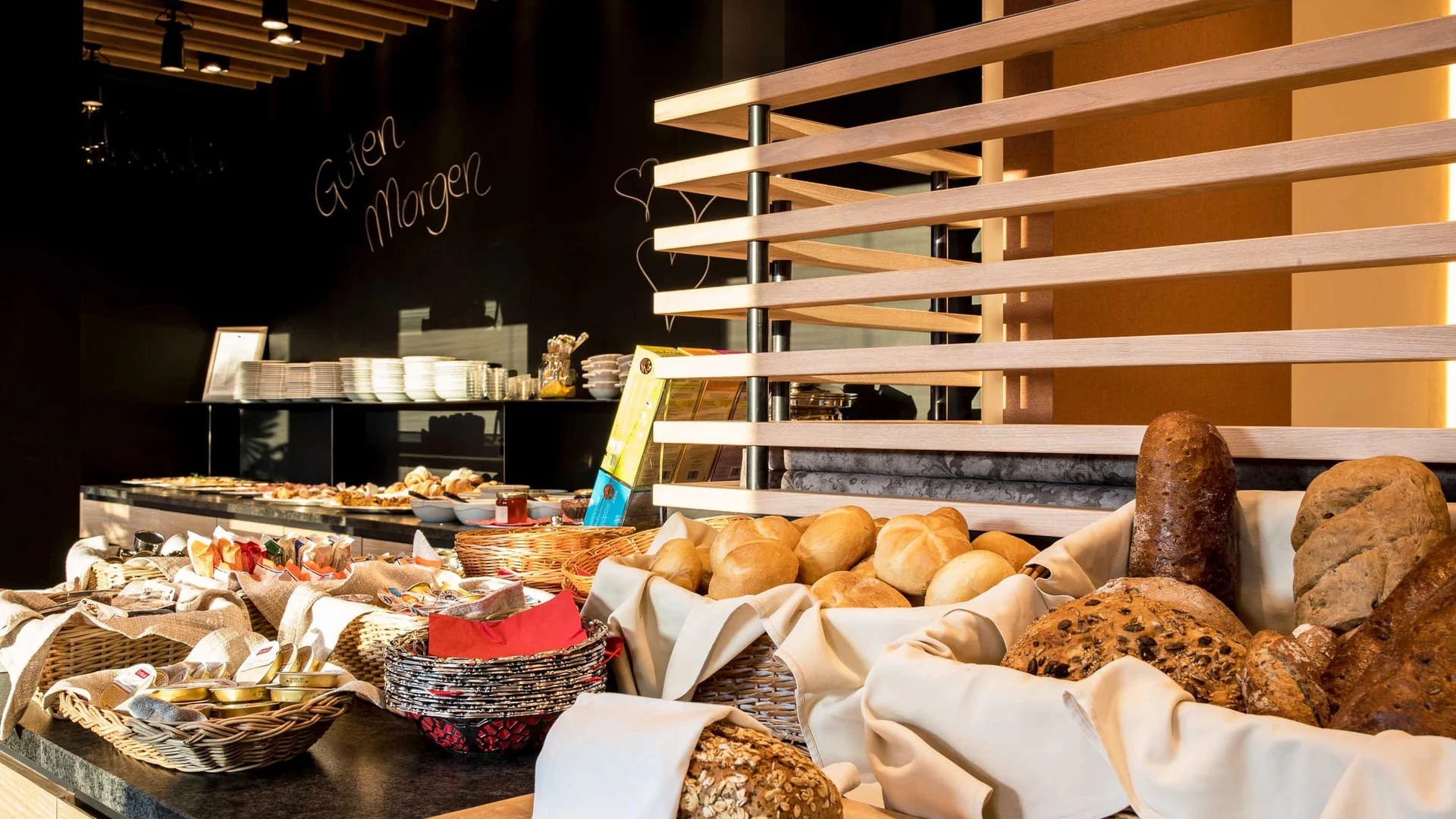 Frühstücksbuffet mit verschiedenen Brotsorten und Brötchen in Körben