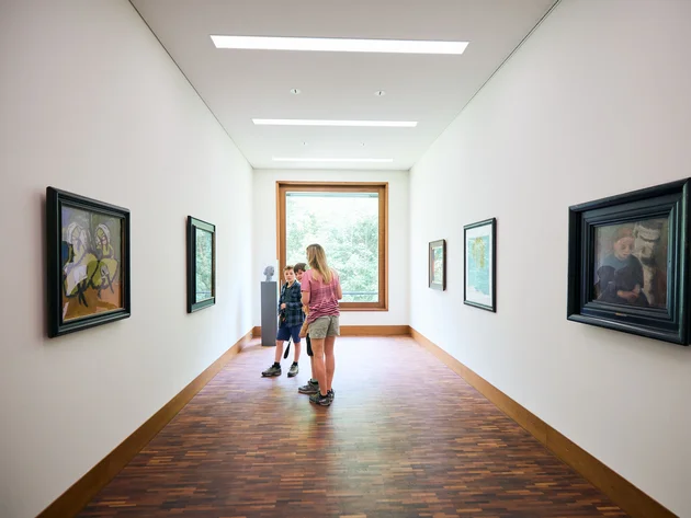 Kinder betrachten Kunstwerke in einem modernen Museumskorridor