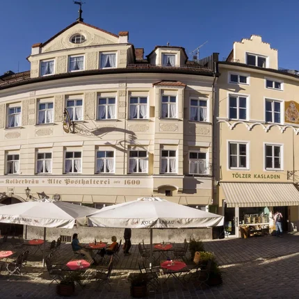 Historisches Gebäude mit Außenbereich eines Cafés in sonniger Stadtstraße