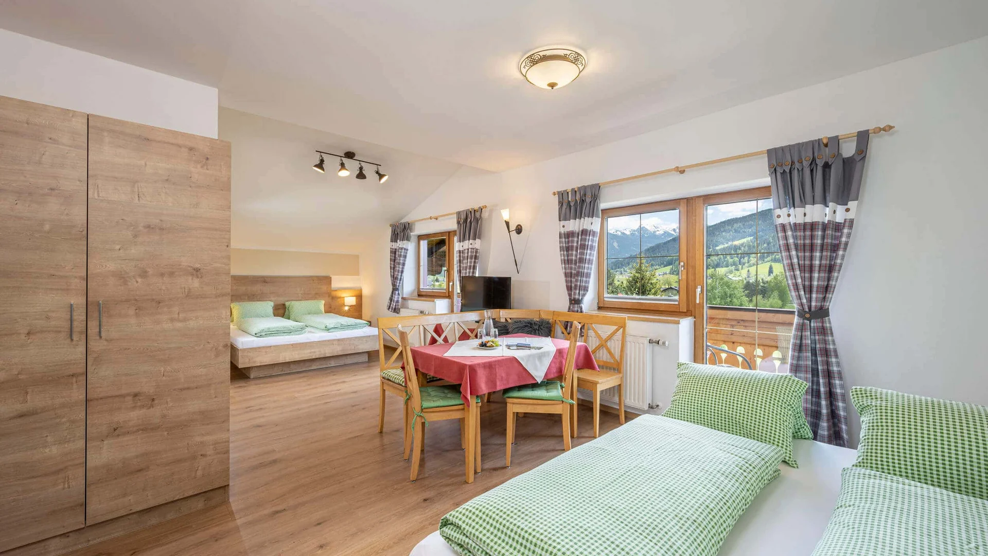 Bright bedroom with wooden furniture and mountain view through large windows