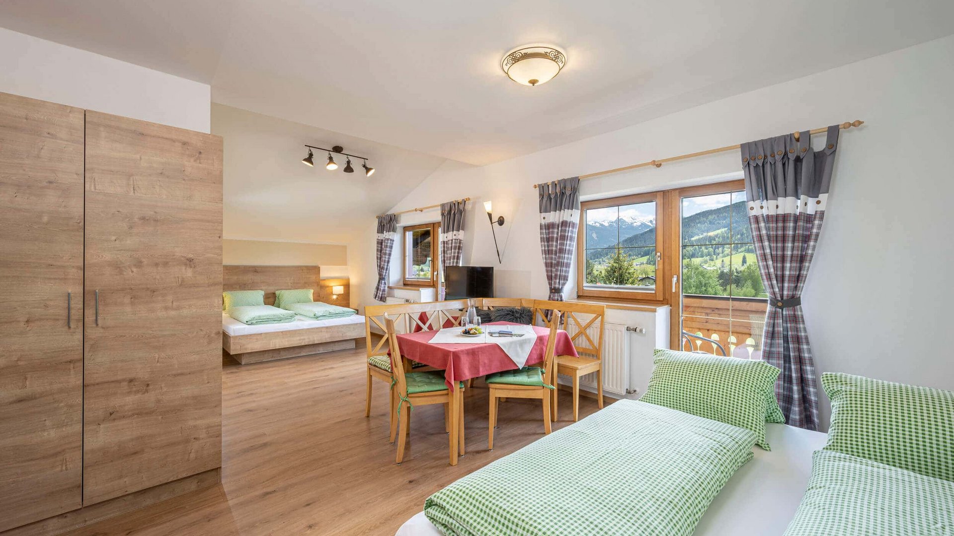 Bright bedroom with wooden furniture and mountain view through large windows