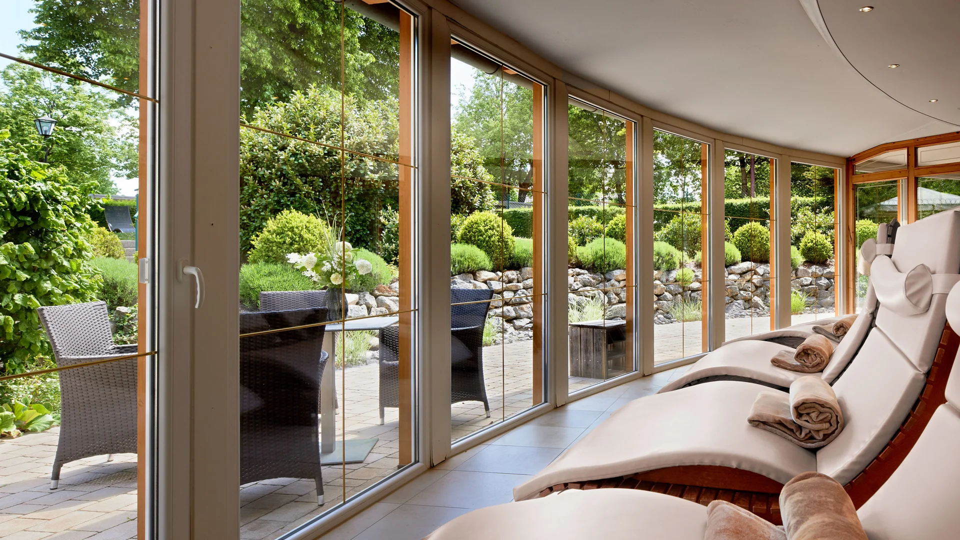 Garden & Spa Hotel das Götzfried **** © Michael Huber Fotographie Ontspanningsruimte met ligstoelen en uitzicht op de tuin door grote ramen