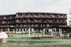 Collective enquiries Modern hotel building with flower boxes and lounge chairs on the lawn