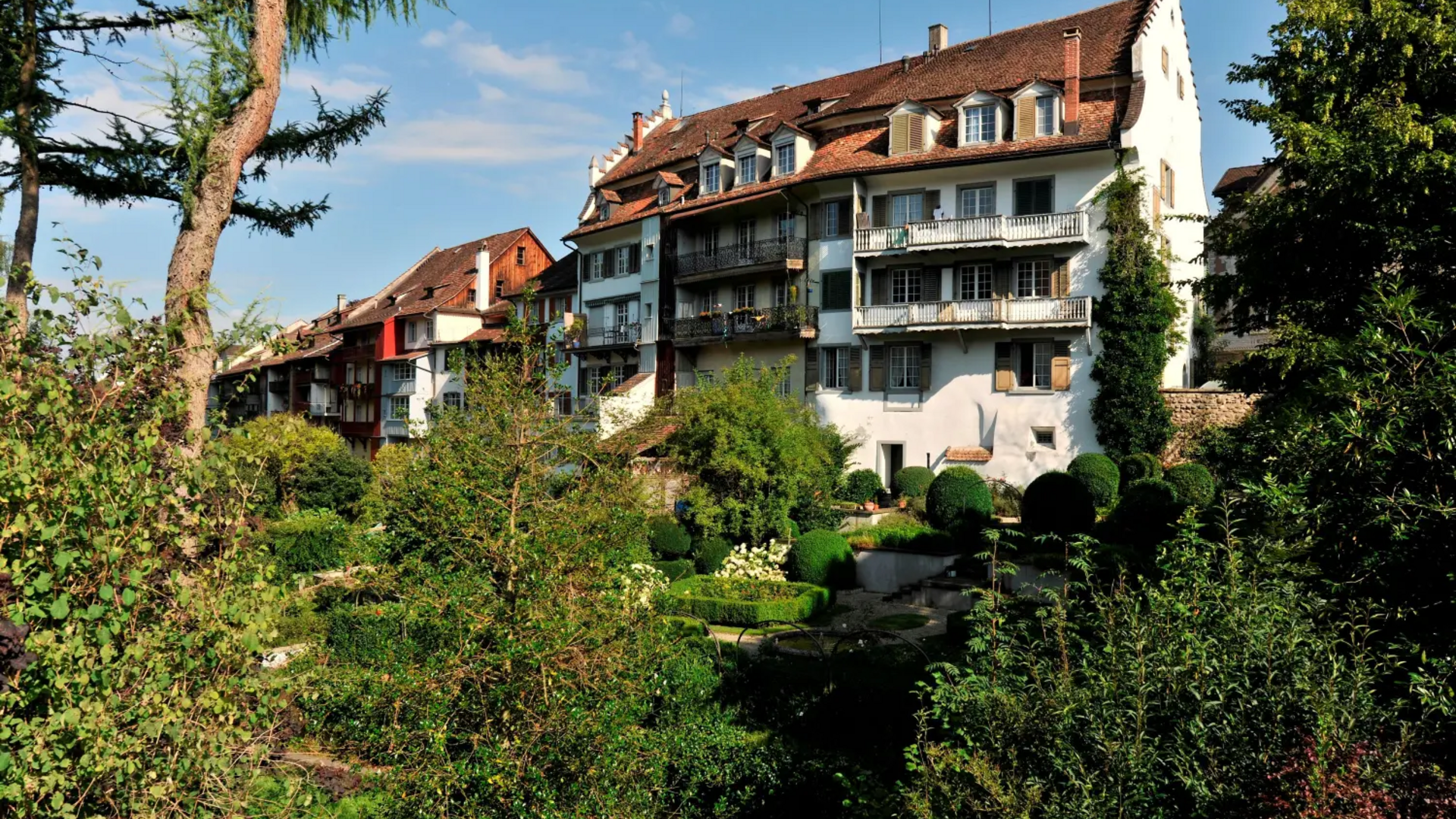 Historic houses with gardens and lush greenery on a sunny day