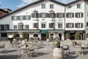 Collectieve vragen © Schwarzer Adler GmbH Buitenkant van hotel Schwarzer Adler met terras en tafels