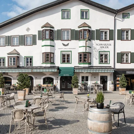 Buitenkant van hotel Schwarzer Adler met terras en tafels