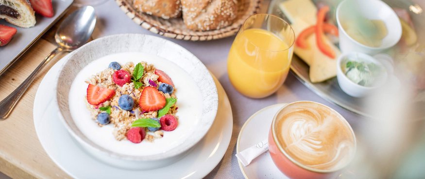 Breakfast with muesli, fresh berries, bread rolls, juice and coffee